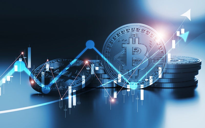 Blue and white charts with arrows intersect shiny bitcoin coins, signifying cryptocurrency growth and financial trends.