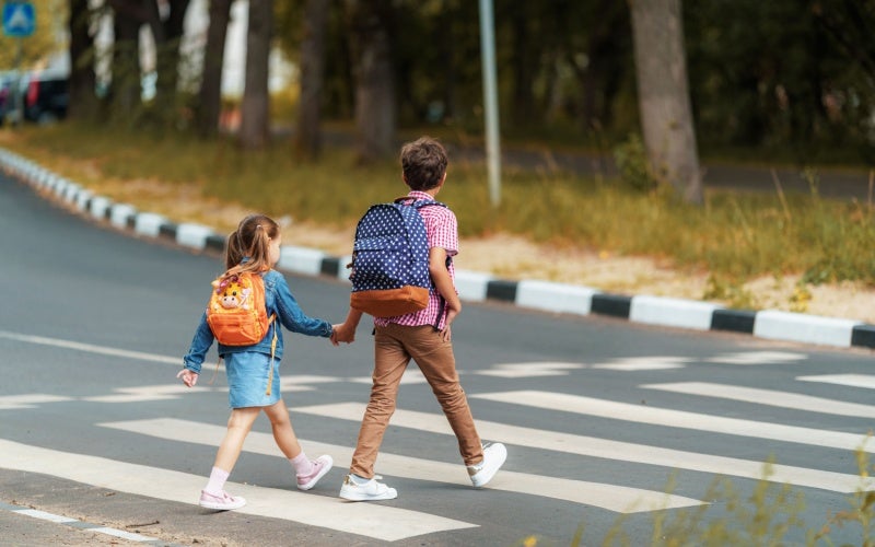Two children crossing the road
